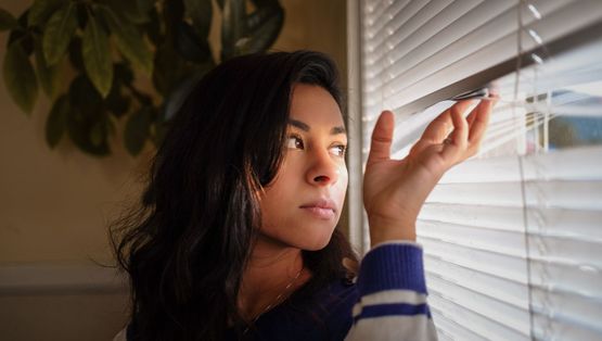 A customer looking through her newly fitted blinds